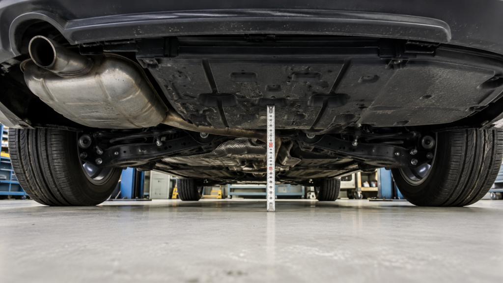Đo khoảng cách từ nền tới điểm thấp nhất dưới gầm xe sedan trong xưởng